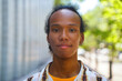 © TrueShot | Westend61 - Confident smiling person outdoors in city looking at camera