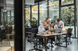 © ty - Group of business people standing together and discussing their work and projects, having a team meeting in an office, view from glass wall