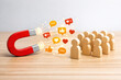 © tonstock - Influence engagement attraction audience connection Magnet imagery showing a red magnet drawing social likes and comments toward a clustered wooden group uplifting mood