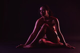 Beautiful nude woman posing on dark background, space for text