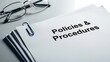 © Musfiqur - Stack of official policies and procedures documents fastened with a paperclip next to glasses.
