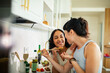 © Marko Geber - Young adult couple cooking together in modern home kitchen, playful