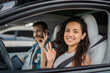 © Vlad - Happy woman and male instructor showing ok gesture while sitting in the car during drive test. Driving test, driver courses, exam concept
