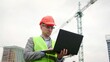 © Vlad - Man inspects territory of construction site outside, use gadget