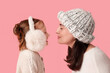© Pixel-Shot - Little girl and her mother in warm sweaters on pink background