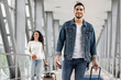 © Prostock-studio - Smiling Middle Eastern Man And Woman Walking With Luggage At Airport, Happy Young Arab Male And Female Holding Suitcases, Having Air Journey, Ready For Vacation Trip, Selective Focus On Guy