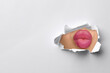 © New Africa - Woman with beautiful plump lips, view through torn hole in white paper