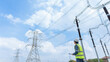 © JD Studio - Engineer inspecting high voltage transmission lines inside electrical substation yard, ensuring power grid reliability, safety compliance, and infrastructure monitoring.