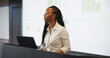 © Flash25/peopleimages.com - Presentation, black woman or speaker with laptop at podium, company stats or performance data discussion. Business growth, pc or employee with projector screen for speech, charts or graphs for info