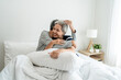 © Kawee - Asian elderly older couple lying down on bed in bedroom at home in morning.