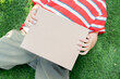 © Kunlathida - Above view of a rectangular cardboard box is in the hands of a young boy