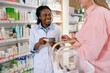 © zinkevych - Young pharmacist advising a female customer on medicines and skin care products
