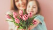 © oksanatukane - Close-up of daughter giving a bouquet of pink tulips to smiling mom, Soft Focus Background. Mother's Day concept. 8th March, womens day and emotional floral themes.