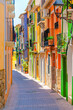 © Aliaksandr - Villajoyosa old town narrow empty pedestrian street with typical colorful houses traditional multicolored buildings in sunny summer day, La Vila Joiosa city historical centre Casco Antiguo, Spain