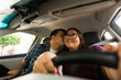 © AntonioDiaz - Smiling woman driving car while man kisses her cheek, showing affection and happiness from inside vehicle