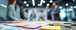 © Rifqi - Blurred image focusing on sticky notes and pens on a table during a meeting with out-of-focus corporate executives, concept for collaboration, planning and strategy