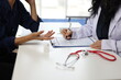 © Wasan - Female doctor documenting patient medical history during a consultation in a hospital office, prescribing treatment, and meticulously filling out medical records for effective care.