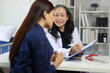 © Wasan - Senior female doctor taking notes on clipboard while listening to her patient explaining her symptoms during medical consultation in hospital room.