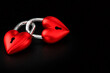 © Ольга Клецкова - Two red heart shaped padlocks linked together on black background for Valentine day concept