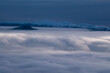 © AmazingAerialAgency - Aerial view of a sea of clouds enveloping the Rakytov mountains, with snow-capped peaks piercing through the misty blanket, Velka Fatra, Zilina Region, Slovakia.