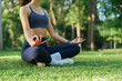 © Phimwilai - Woman meditating in lotus pose outdoors in park