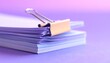 © Rahmat  - Close up view of a large stack of purple colored documents bound tightly together with a shiny golden binder clip on an aesthetic lavender desk background space to text. copy text.