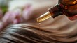 © Nadiia - Golden hair oil dripping from glass bottle onto healthy brown hair in soft natural light closeup