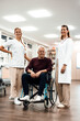 © Westend61 - Doctor and nurse supporting patient in wheelchair during hospital rehabilitation