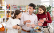 © JackF - Positive family with teenage girl choosing packed hamburger in grocery store