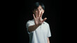 © MiMoShi - man open palm stop gesture communication safety awareness isolated black background studio