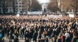 © indah - Large outdoor gathering of individuals, possibly a demonstration or rally, with banners and signs, blurry in the distance