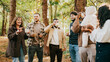 © Reuben - A group of people are standing in a forest, drinking coffee and laughing. Scene is cheerful and relaxed