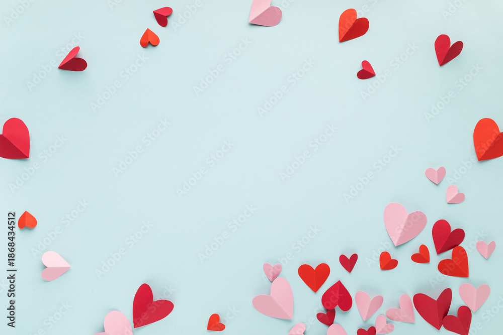 Saint Valentine or Mother's Day hearts decoration on blue background top view. Festive frame for love greeting and holiday celebration.