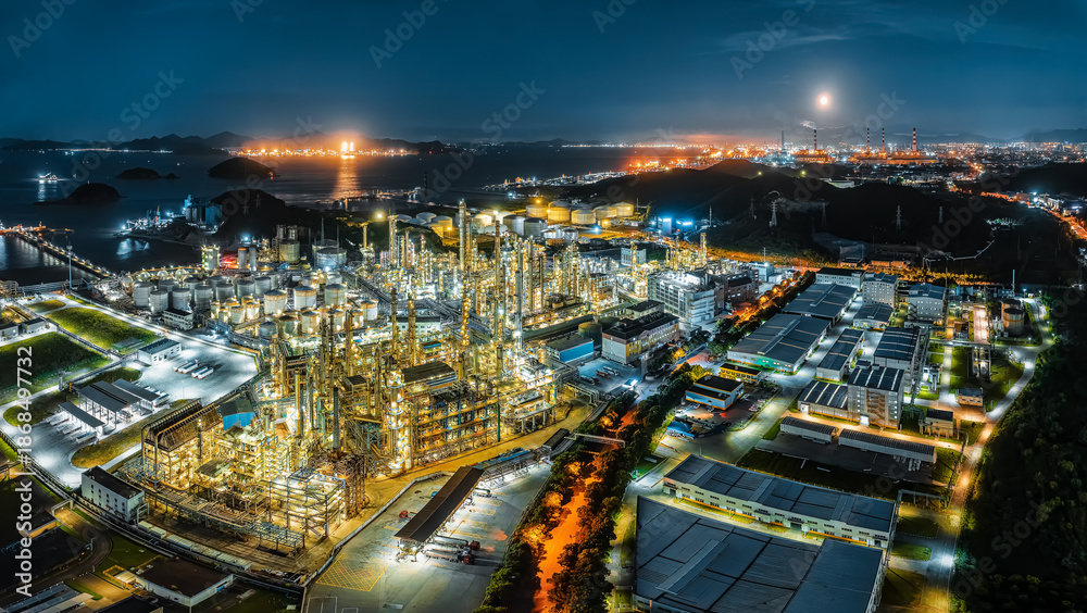 Massive oil refinery and chemical plant illuminated with bright lights ...