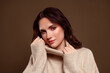 © Beauty Hero - Charming young woman in cozy beige sweater posing confidently against a neutral gradient background