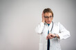 © Nenad - Worried female doctor looking at wristwatch, isolated with copy space (74 karaktera)
