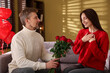 © New Africa - Happy man surprising his girlfriend with bouquet of roses indoors. Valentine's day celebration