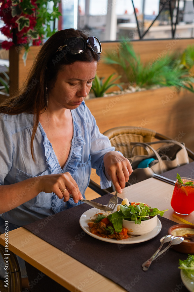 Dining at a beach resort while enjoying a meal with a view of the sea during daytime hours