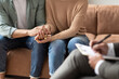 © Prostock-studio - Help Concept. Closeup Cropped View Of Spouses Having Session With Male Marriage Therapist, Sitting On Couch In Office And Holding Each Other Hands. Consultant Writing Taking Notes, Selective Focus