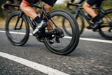 Cyclists Racing In Motion On Urban Road.
Close up view of cyclists legs and wheels during a road race, capturing speed, teamwork and athletic energy on asphalt in a dynamic competitive cycling scene.