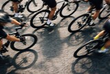 Cyclists Racing In Motion On Urban Road.
Close up view of cyclists legs and wheels during a road race, capturing speed, teamwork and athletic energy on asphalt in a dynamic competitive cycling scene.