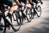 Cyclists Racing In Motion On Urban Road.
Close up view of cyclists legs and wheels during a road race, capturing speed, teamwork and athletic energy on asphalt in a dynamic competitive cycling scene.