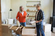 © zinkevych - Husband and wife unpacking together cardboard boxes in living room
