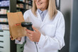 © zinkevych - Pharmacist scanning the qr code on the package with medicines