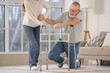 © Pixel-Shot - Young woman helping her grandfather to stand up after fall with walker at home