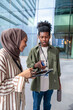 © Jovo Jovanovic/Stocksy - Two young professionals review a tablet outside a modern building.