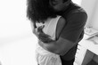 © Rob and Julia Campbell/Stocksy - Caring hug between two people in warm black and white