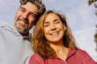 © Adrian Rodd/Stocksy - Close-up selfie of a middle-aged couple grinning at the camera
