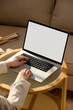 © Marc Tran/Stocksy - Person working on a laptop computer at home on a small wooden table