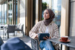 © Jovo Jovanovic/Stocksy - Woman in hijab works on tablet at outdoor cafe.